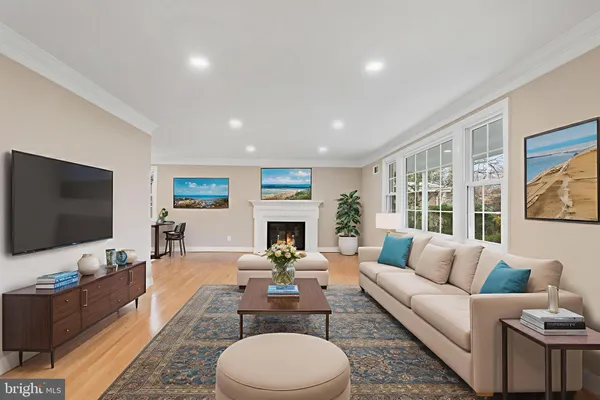 a living room with furniture a rug a flat screen tv and a large window
