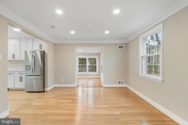 a view of kitchen with stainless steel appliances wooden floor and a window