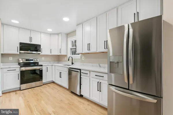 a kitchen with stainless steel appliances and refrigerator