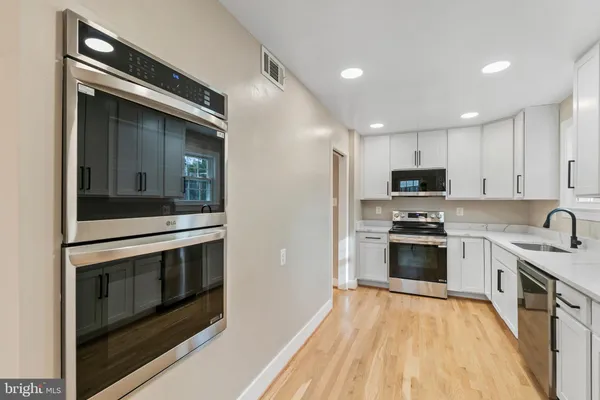 a kitchen with stainless steel appliances a stove sink and microwave