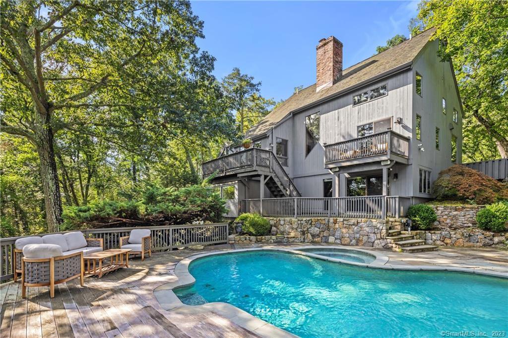 a front view of a house with swimming pool having outdoor seating