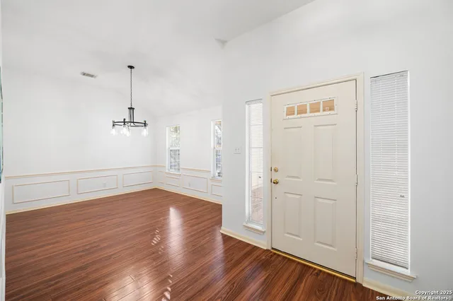 a view of an empty room with wooden floor