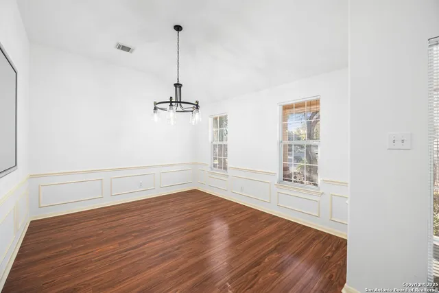 a view of empty room with wooden floor and window