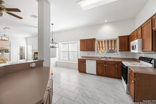 a large kitchen with stainless steel appliances granite countertop a sink stove and cabinets