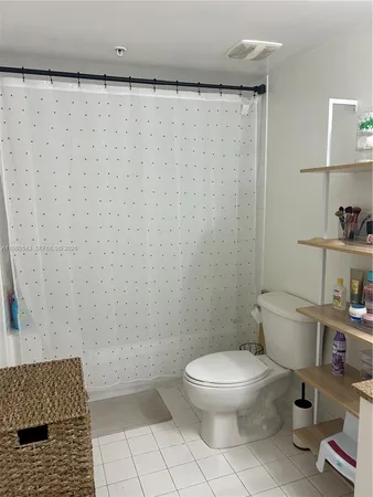 a white toilet sitting next to a shower curtain