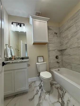 a bathroom with a granite countertop toilet a sink and bathtub