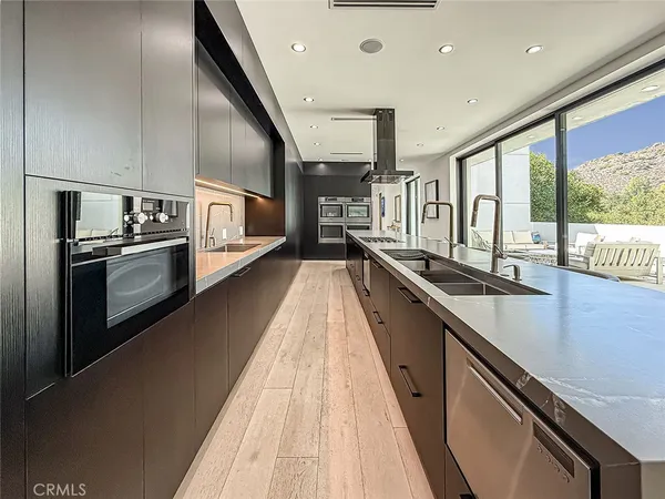 a large kitchen with stainless steel appliances kitchen island a large counter top and a stove