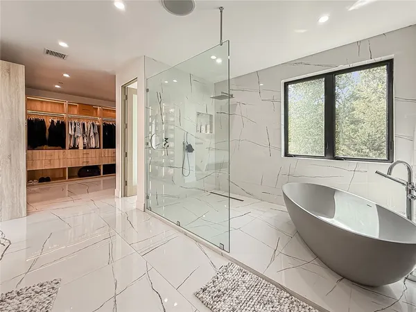 a large spacious bathroom with a large tub shower and windows