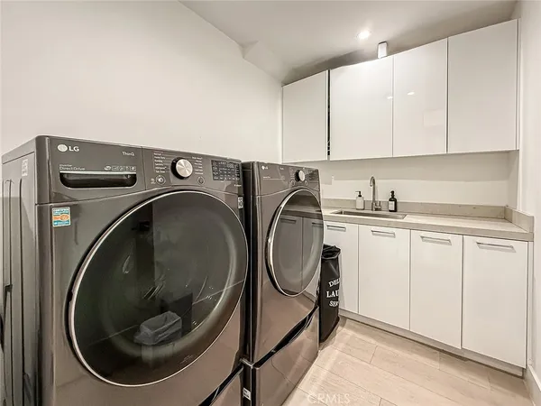 a utility room with sink dryer and washer