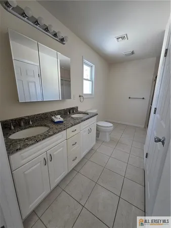 a spacious bathroom with a granite countertop sink and a mirror