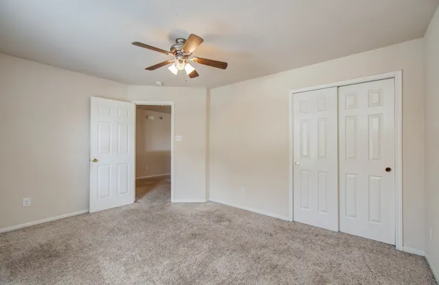 an empty room with a window and a fan