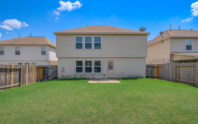 a backyard of a house with table and chairs