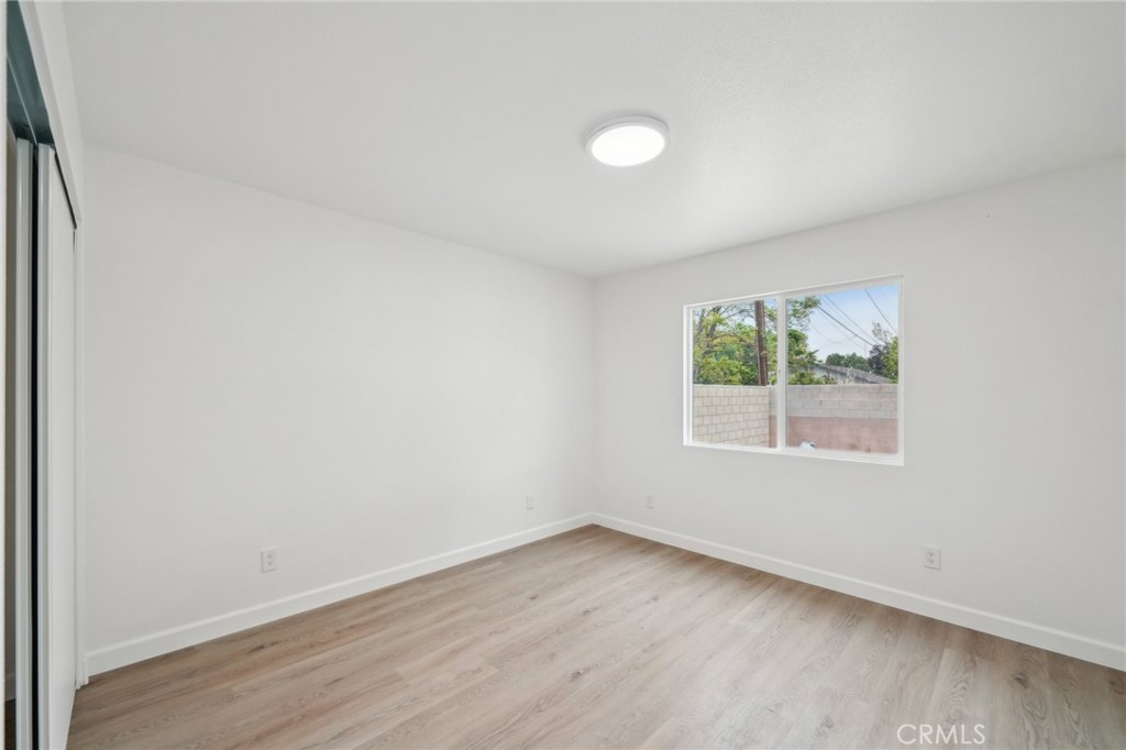 4664 Sierra Street Riverside, CA 92504 - Photo 12 of 30 an empty room with wooden floor and windows