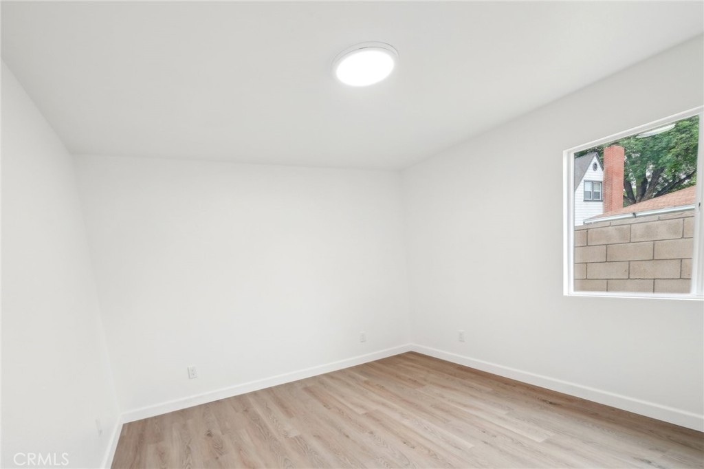 4664 Sierra Street Riverside, CA 92504 - Photo 14 of 30 a view of an empty room with wooden floor and a window