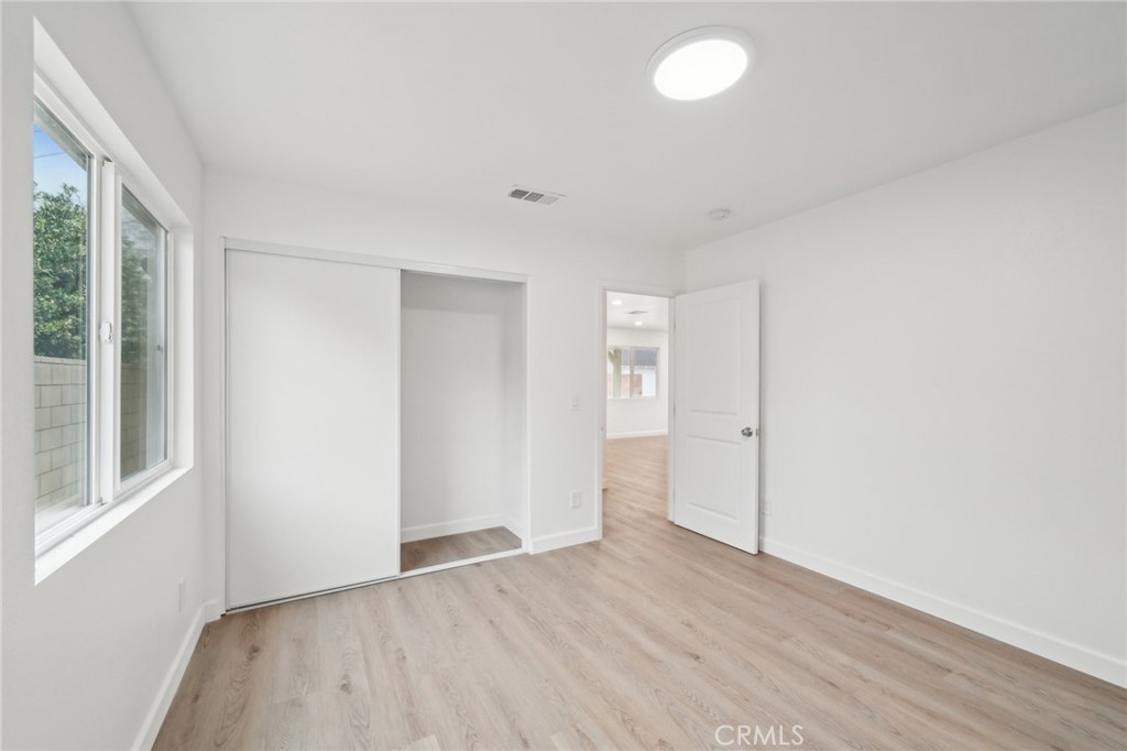 4664 Sierra Street Riverside, CA 92504 - Photo 16 of 30 an empty room with wooden floor and windows