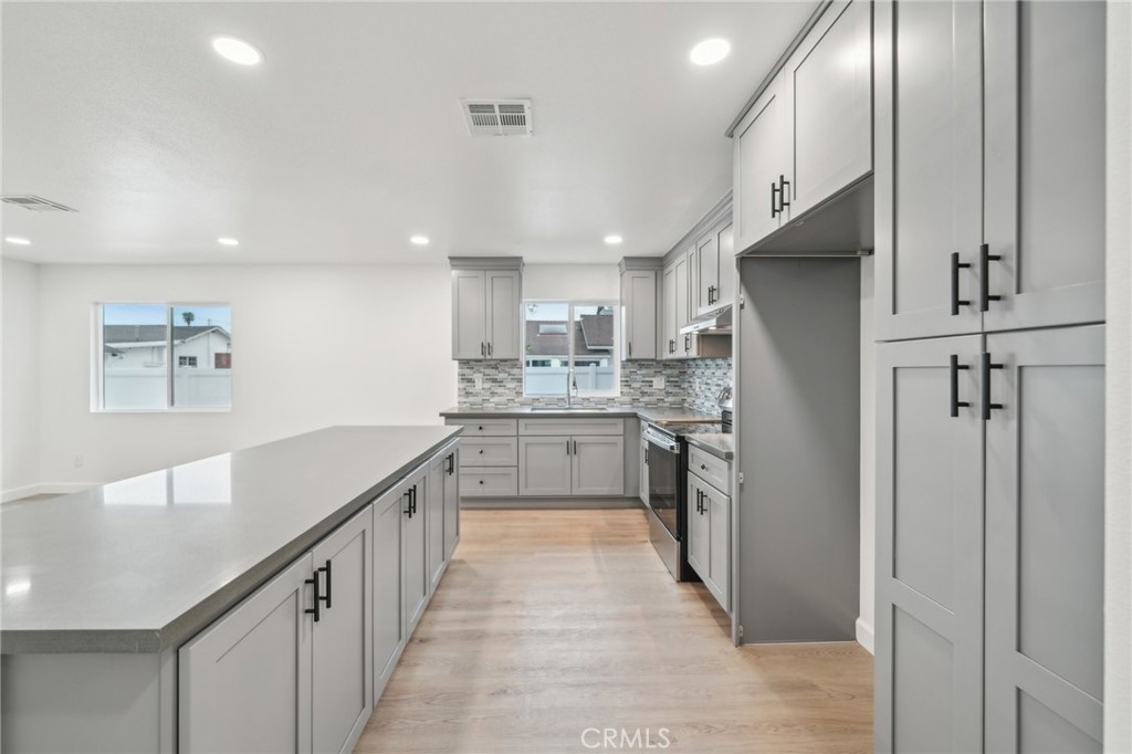4664 Sierra Street Riverside, CA 92504 - Photo 8 of 30 a kitchen with kitchen island white cabinets and stainless steel appliances