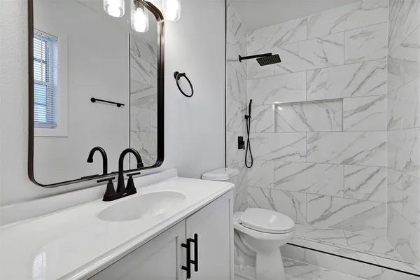 a bathroom with a sink a toilet and shower