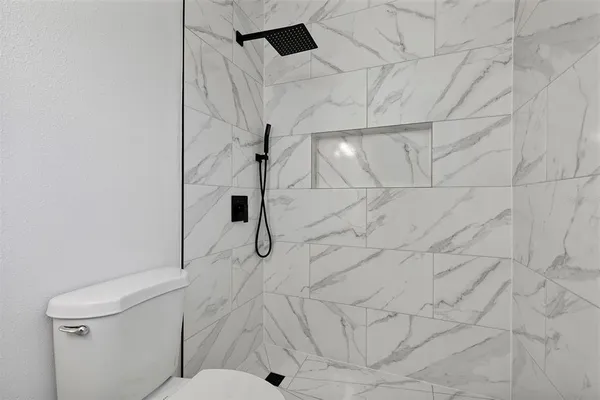 a bathroom with a toilet and a shower