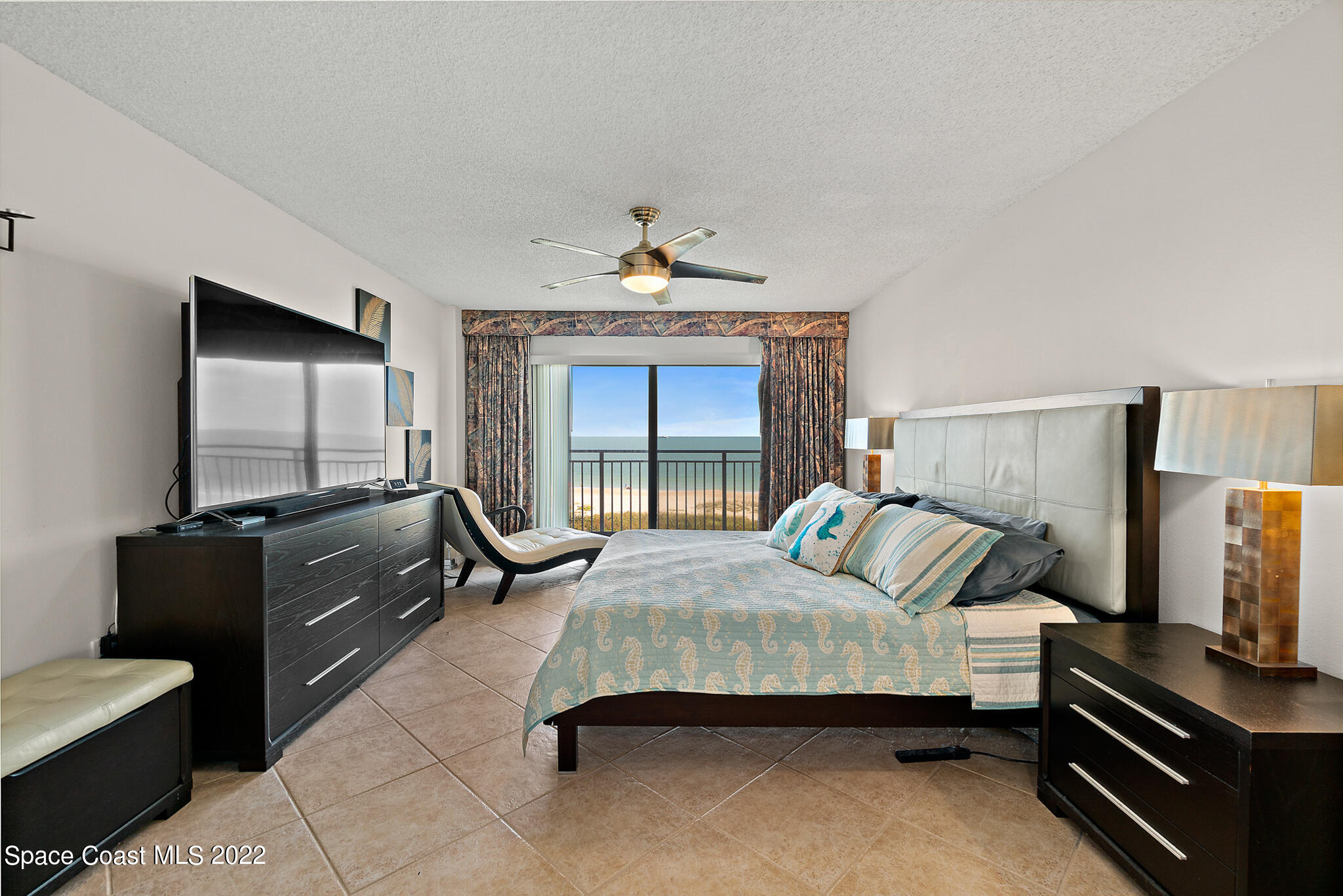 6770 Ridgewood Avenue, Unit 502 Cocoa Beach, FL 32931 - Photo 11 of 25 a bedroom with a bed and a flat screen tv