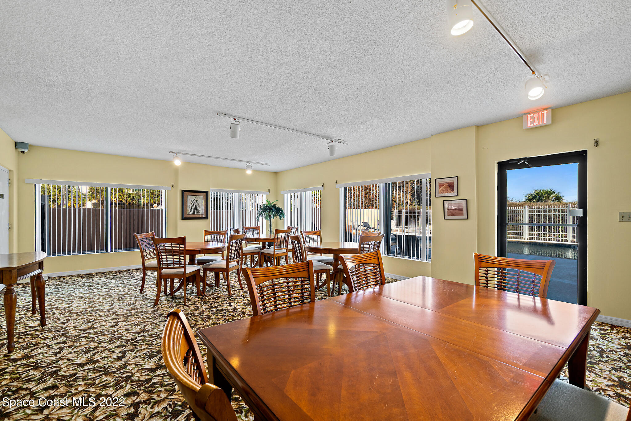 6770 Ridgewood Avenue, Unit 502 Cocoa Beach, FL 32931 - Photo 18 of 25 a dining room with furniture wooden floor a rug and a large window