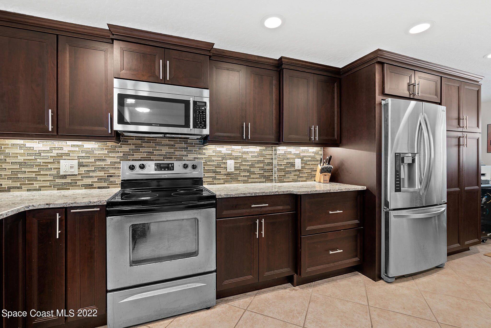 6770 Ridgewood Avenue, Unit 502 Cocoa Beach, FL 32931 - Photo 5 of 25 a kitchen with a refrigerator stove and sink