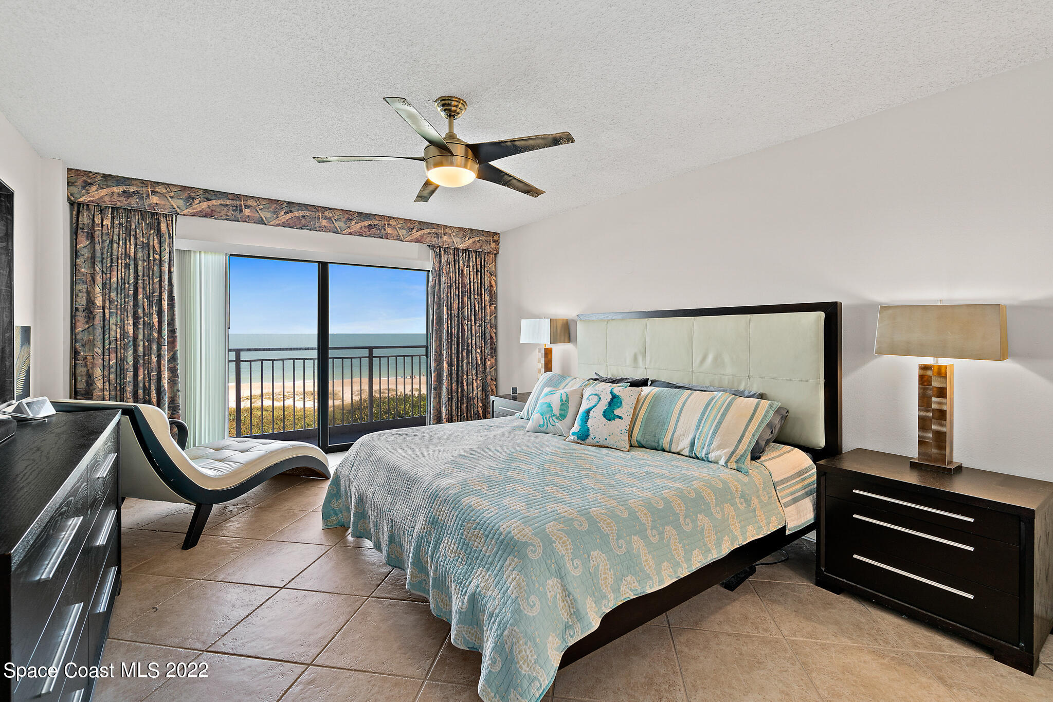 6770 Ridgewood Avenue, Unit 502 Cocoa Beach, FL 32931 - Photo 10 of 25 a bed room with a bed and a chandelier