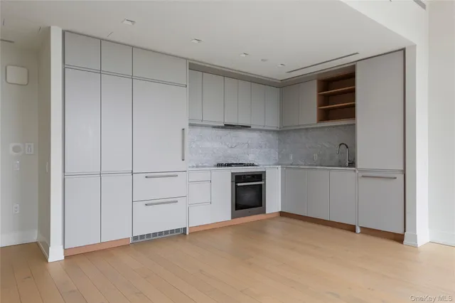 a kitchen with granite countertop white cabinets and stainless steel appliances