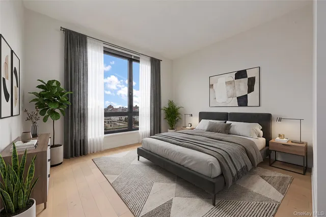 a bedroom with a large bed and a potted plant