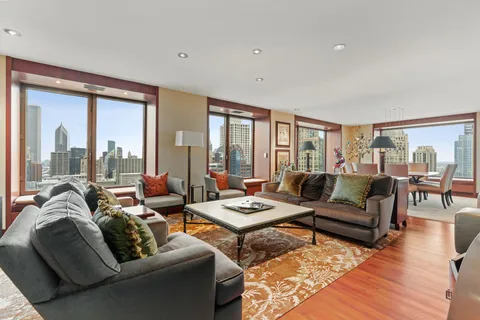 a living room with furniture and floor to ceiling windows