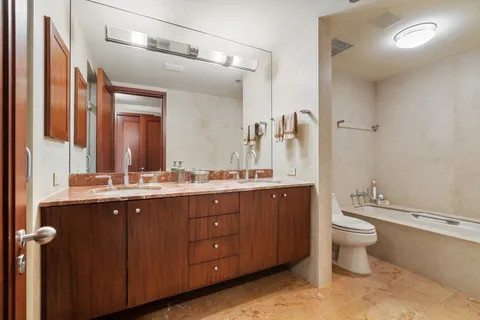 a bathroom with a double vanity sink mirror and shower