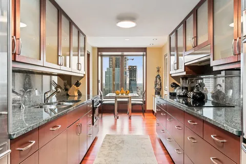 a large kitchen with stainless steel appliances granite countertop a lot of counter space and a window