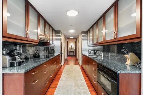 a large kitchen with stainless steel appliances granite countertop a lot of counter space and a sink