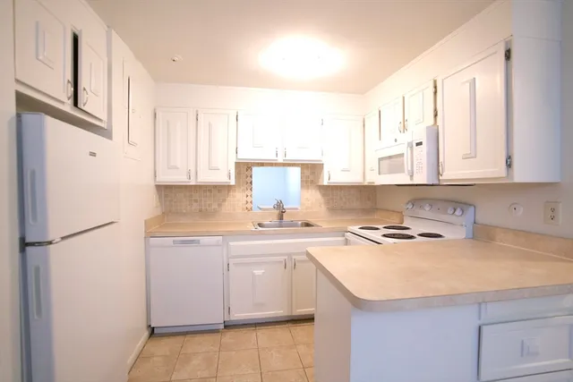 a kitchen with a sink a refrigerator and cabinets
