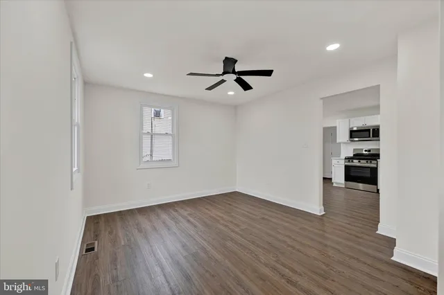 a view of empty room with wooden floor