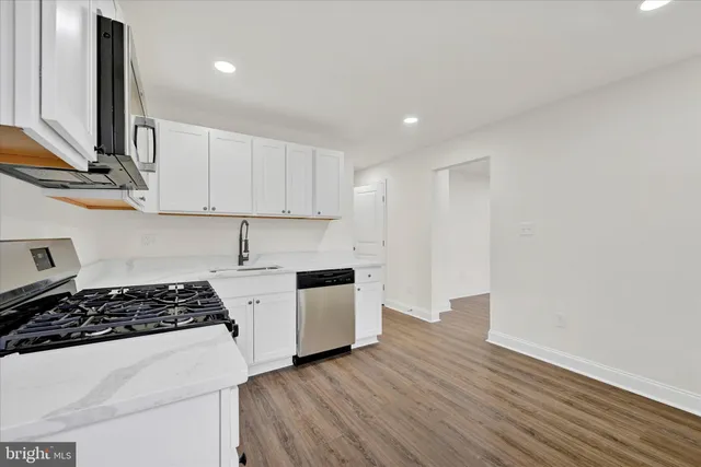 a kitchen with wooden floor a stove and a sink