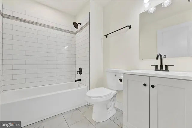 a bathroom with a bathtub shower sink vanity and toilet