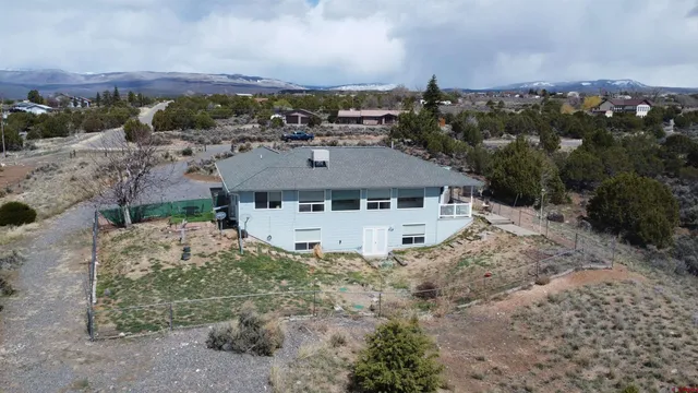 an aerial view of a house with yard and trees in front of it