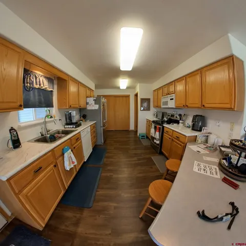 a living room with a couch dining table wooden floor and a rug