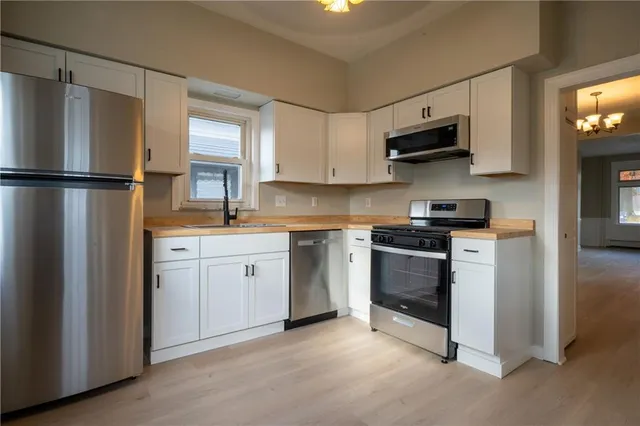 a kitchen with stainless steel appliances white cabinets and a sink