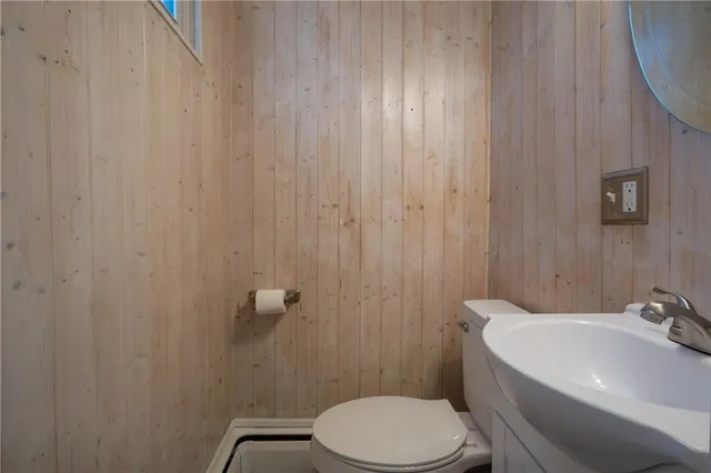 a white toilet sitting next to a white sink and a shower curtain