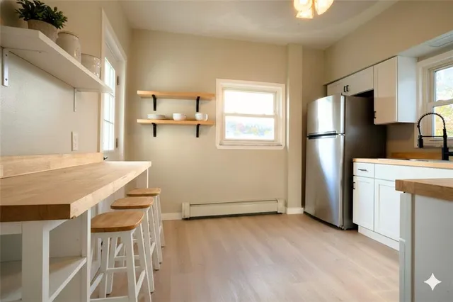 a kitchen with kitchen island a refrigerator stove and sink