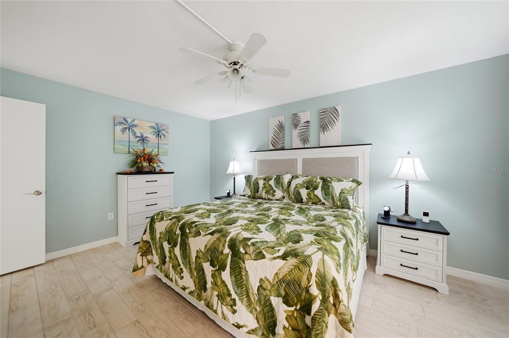 1 Colony Point Drive, Unit A10 Punta Gorda, FL 33950 - Photo 22 of 31 a bedroom with a bed and a lamp on dresser