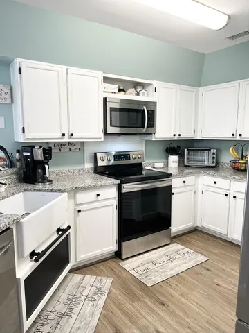 a kitchen with stainless steel appliances granite countertop a stove a sink and a microwave