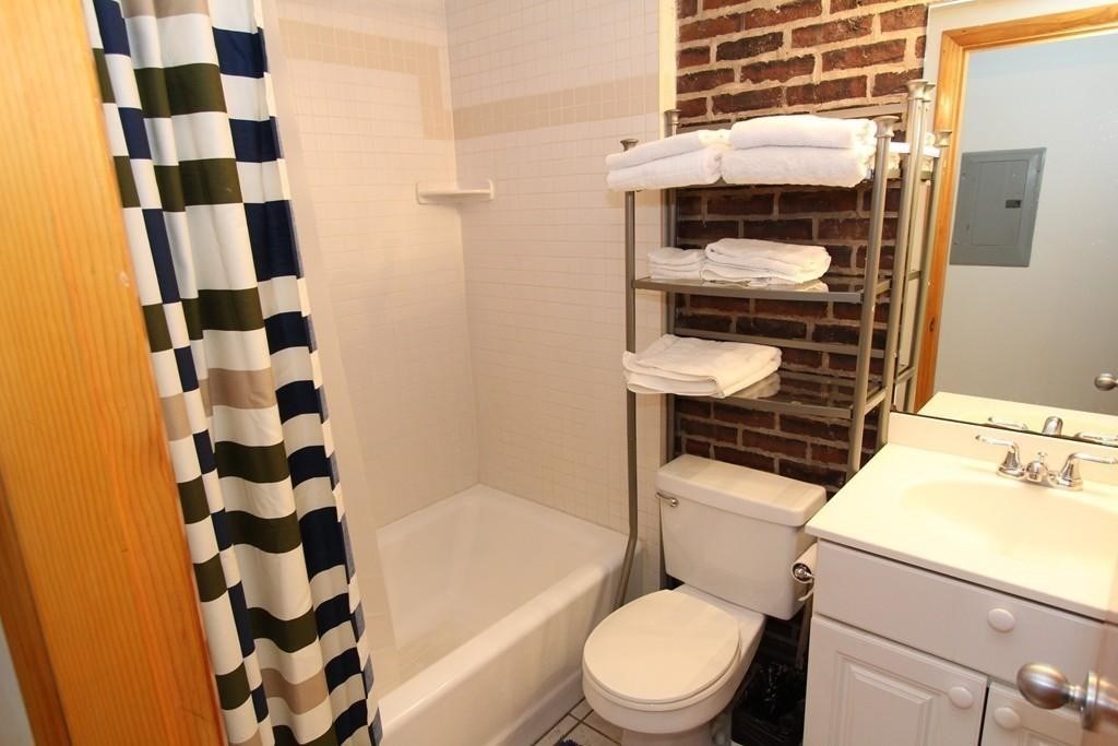 49-51 Temple Place, Unit 2R Boston, MA 02111 - Photo 7 of 7 a bathroom with a sink toilet and shower