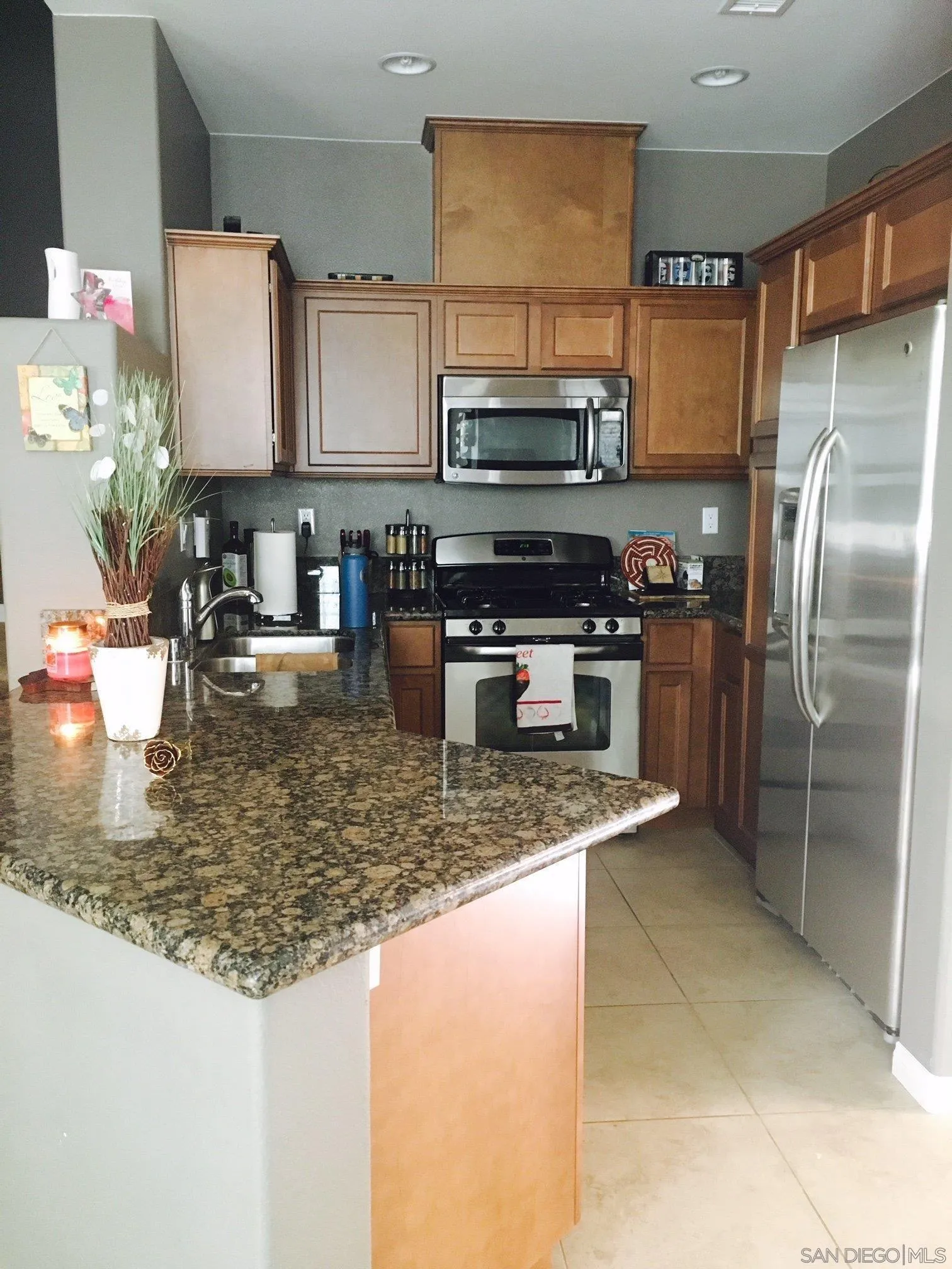 5074 Cascade Way, Unit 101 Oceanside, CA 92057 - Photo 7 of 12 a kitchen with stainless steel appliances granite countertop a sink refrigerator and microwave