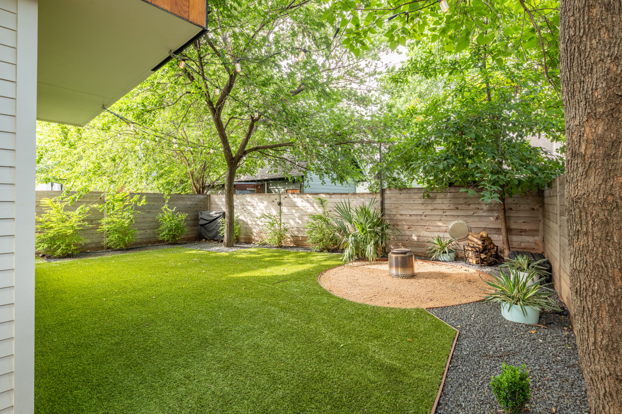 1811 Collier Street Austin, TX 78704 - Photo 34 of 40 Manicured backyard featuring artificial turf and a circular gravel patio area