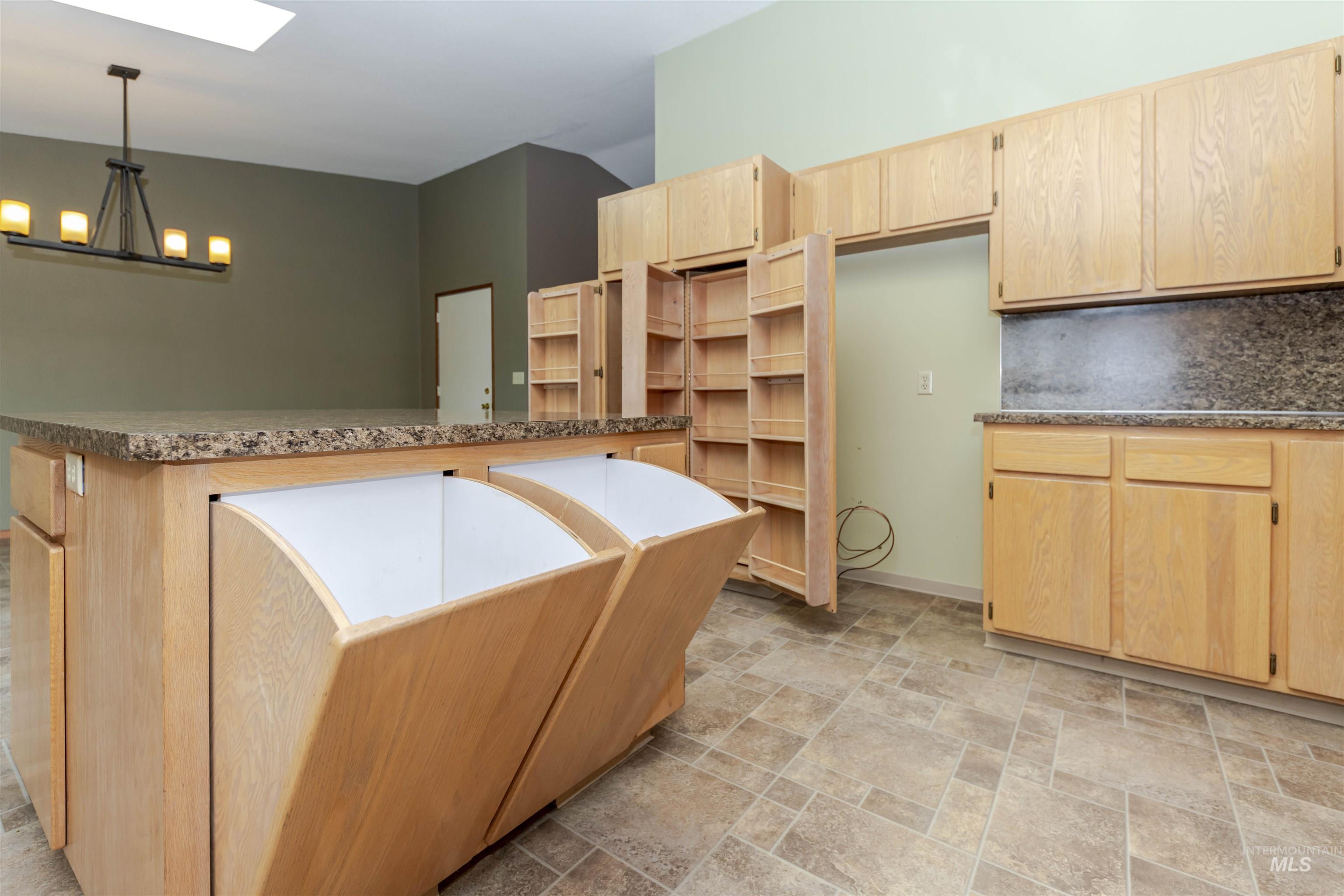 1316 29th Street Lewiston, ID 83501 - Photo 12 of 31 Kitchen with light wood finish cabinetry, stone finish floors, a skylight, hanging lights, and dry food storage