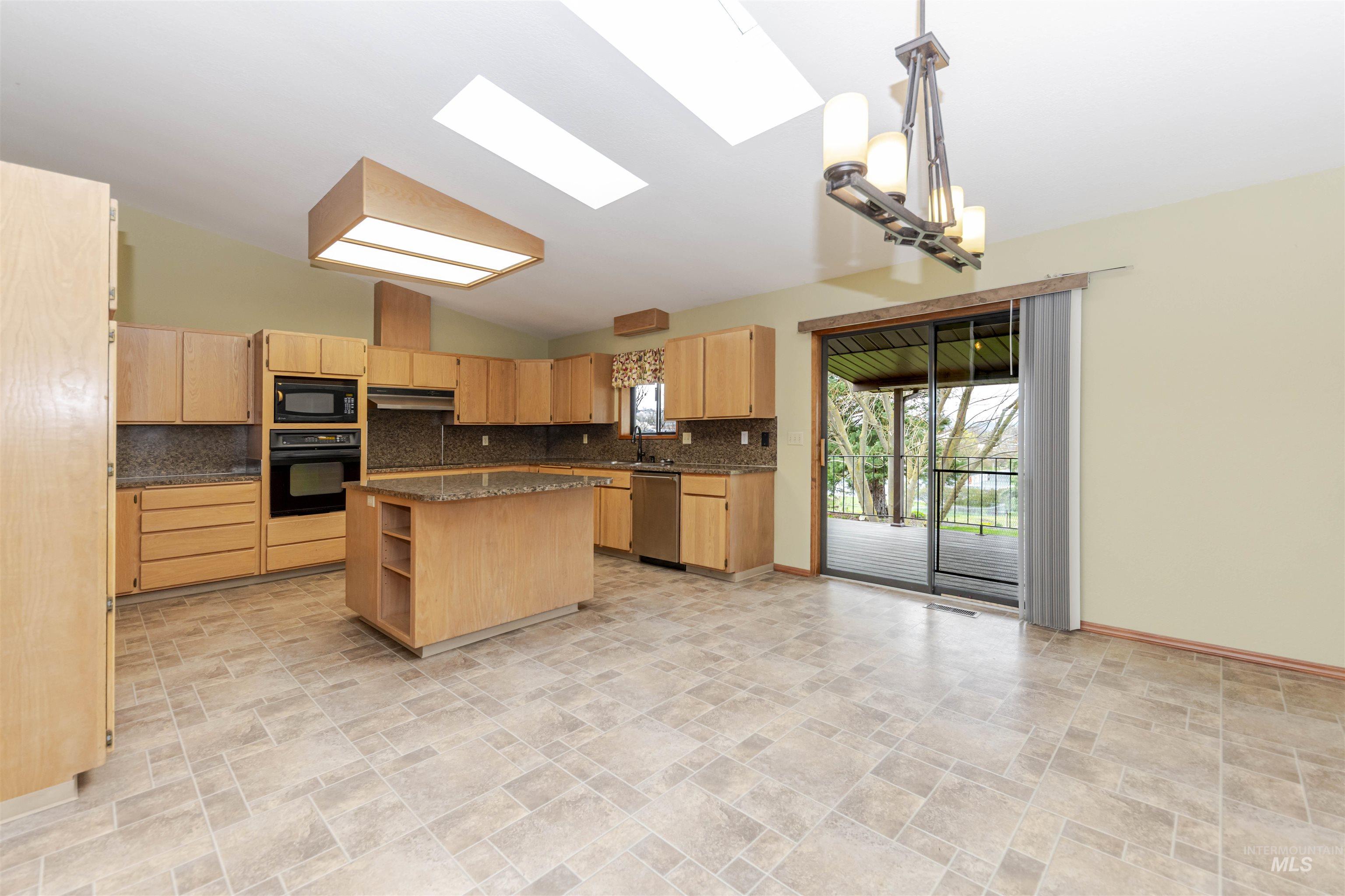 1316 29th Street Lewiston, ID 83501 - Photo 5 of 31 Kitchen with stone finish flooring, open shelves, a skylight, light wood finish cabinets, and lofted ceiling