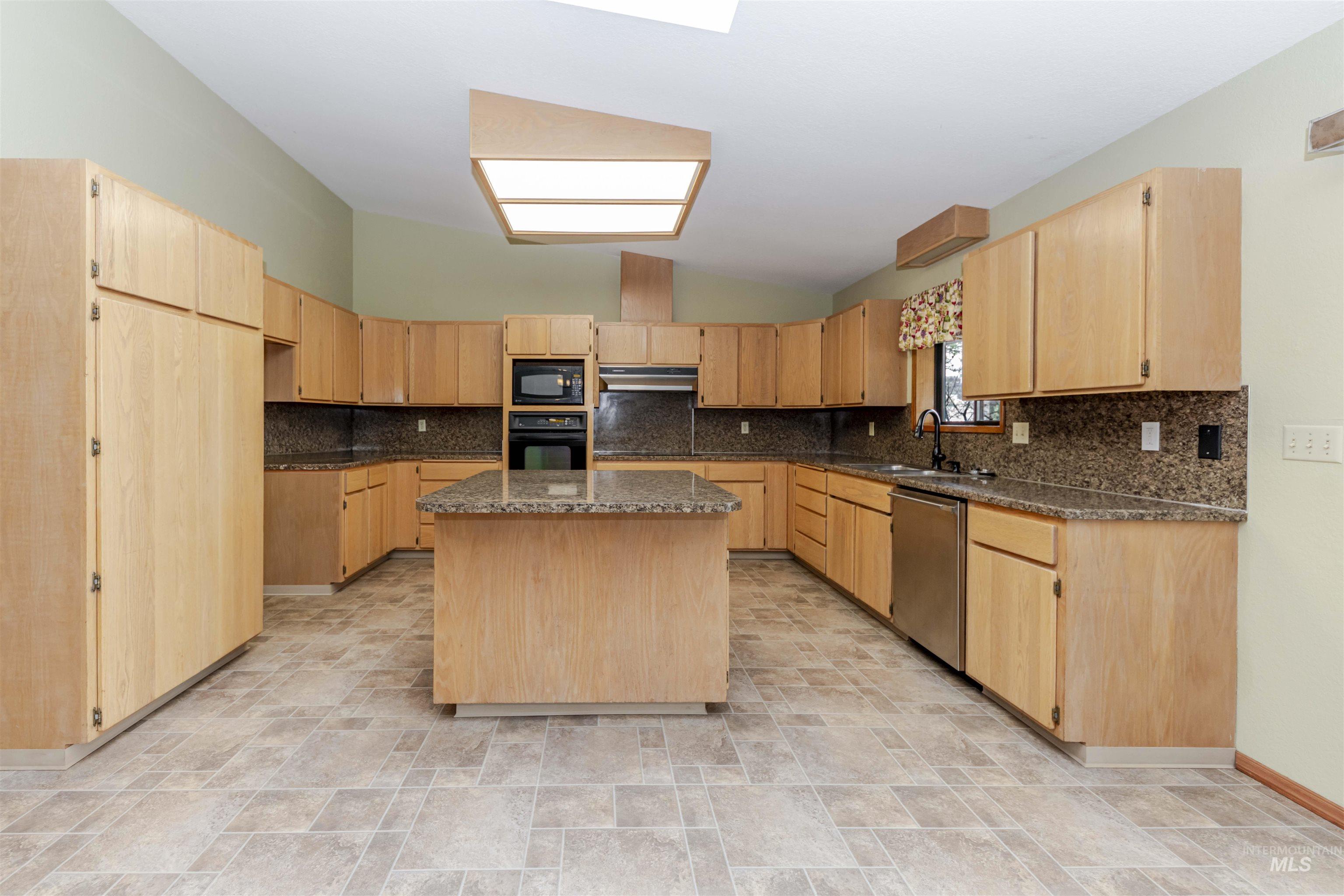 1316 29th Street Lewiston, ID 83501 - Photo 6 of 31 Kitchen featuring light wood finish cabinets, stone finish floors, and lofted ceiling