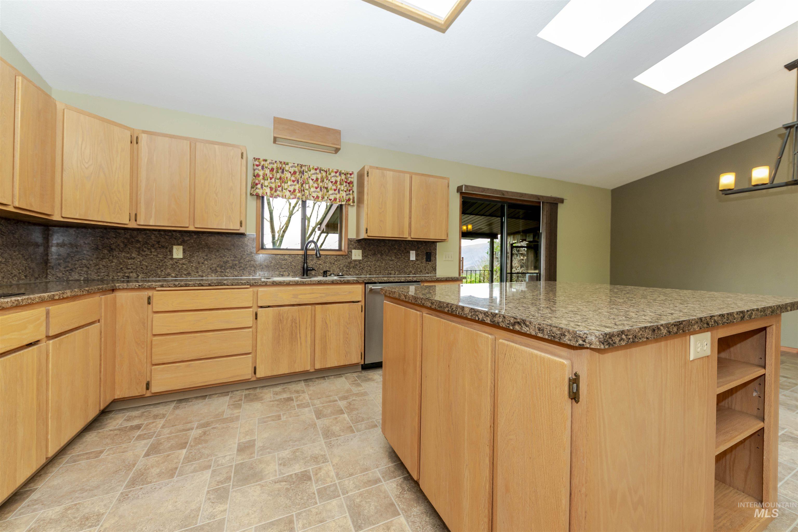 1316 29th Street Lewiston, ID 83501 - Photo 7 of 31 Kitchen featuring light wood finish cabinetry, lofted ceiling, stone finish floors, and open shelves